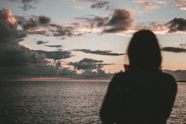 Woman standing alone on the beach