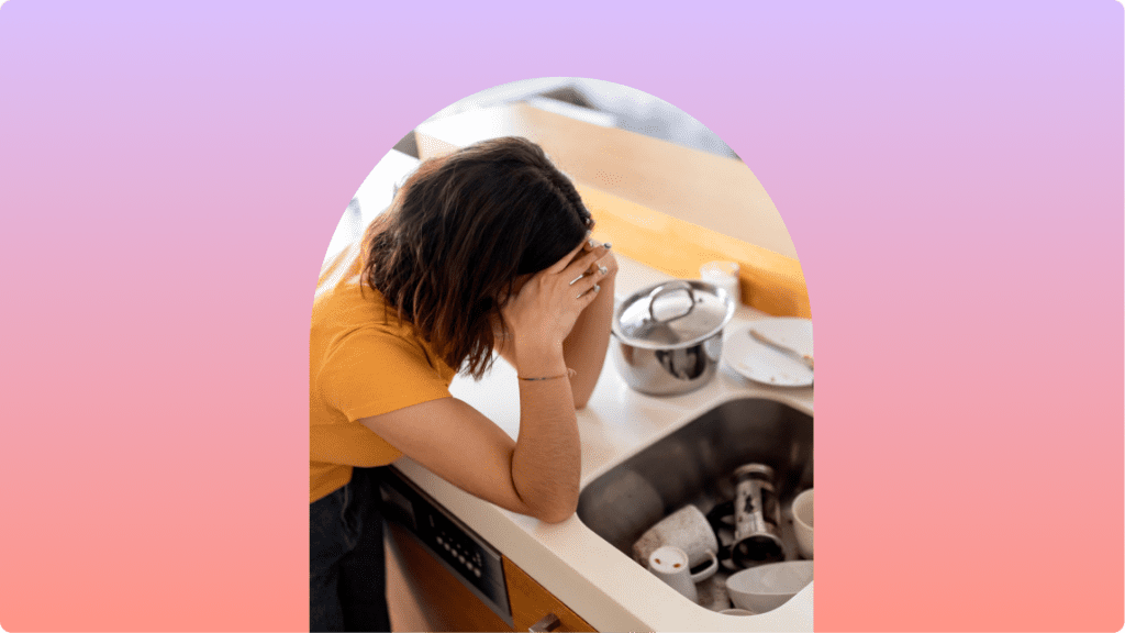 a woman near a sink with her hands on her face