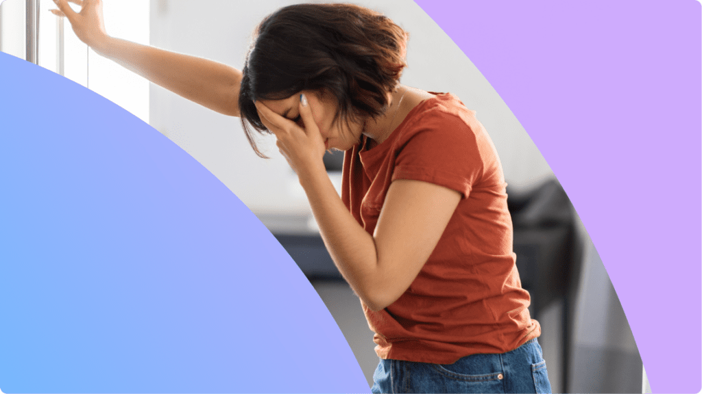 A person holding their head, looking like they feel sick