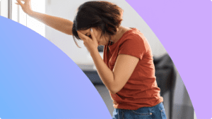 A person holding their head, looking like they feel sick