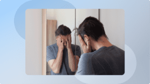 a person standing in front of the mirror, covering their face