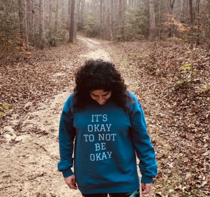 Mollie Albanese walking along a leaf-covered trail