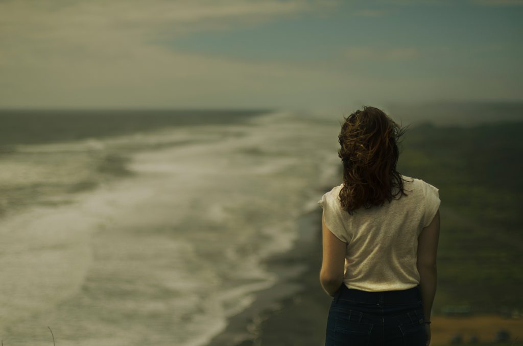 A woman standing alone on the beach