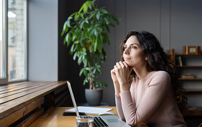 Woman looking out of a window confidently.