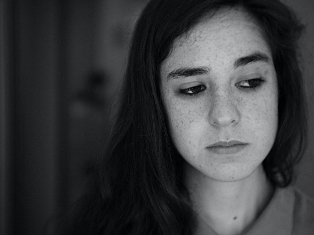 Black and white image of woman looking sad and anxious 